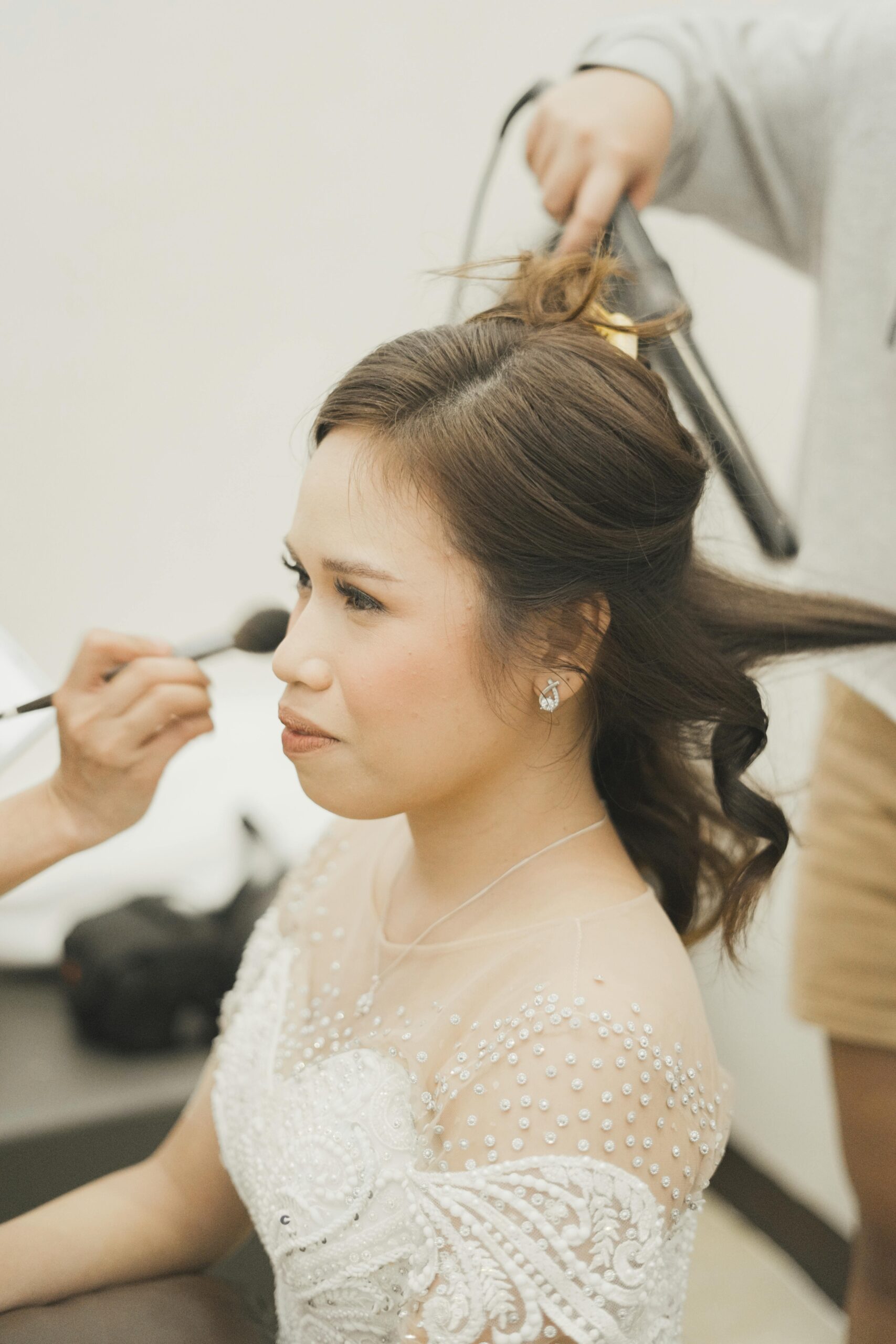 Novia durante la preparación mientras le realizan maquillaje y peinado.